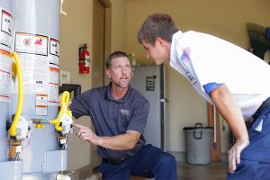 Technician explaining water heater components to a coworker