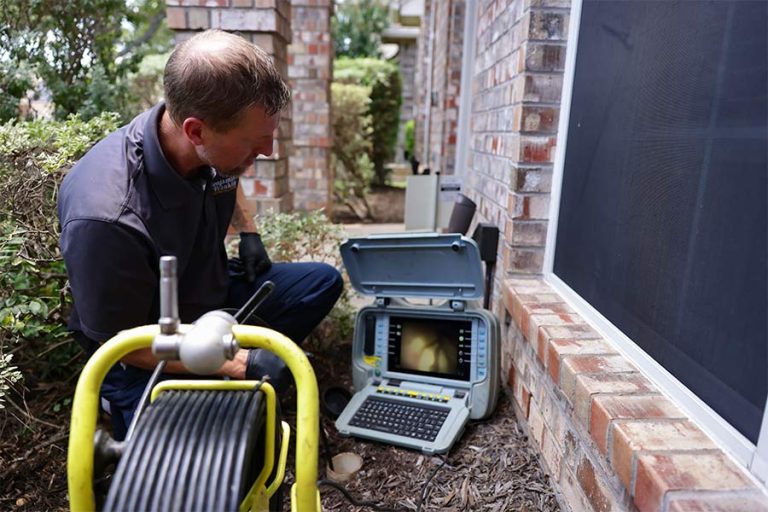 Plumber diagnosing a clogged drain with a sewer camera